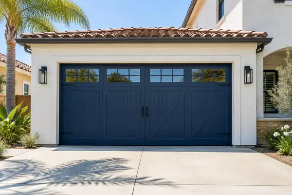 New navy carriage style garage door on a stucco home