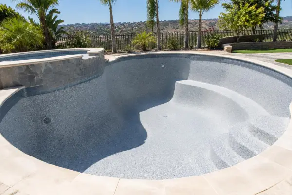 Empty pool with a fresh pebble plaster finish ready to fill